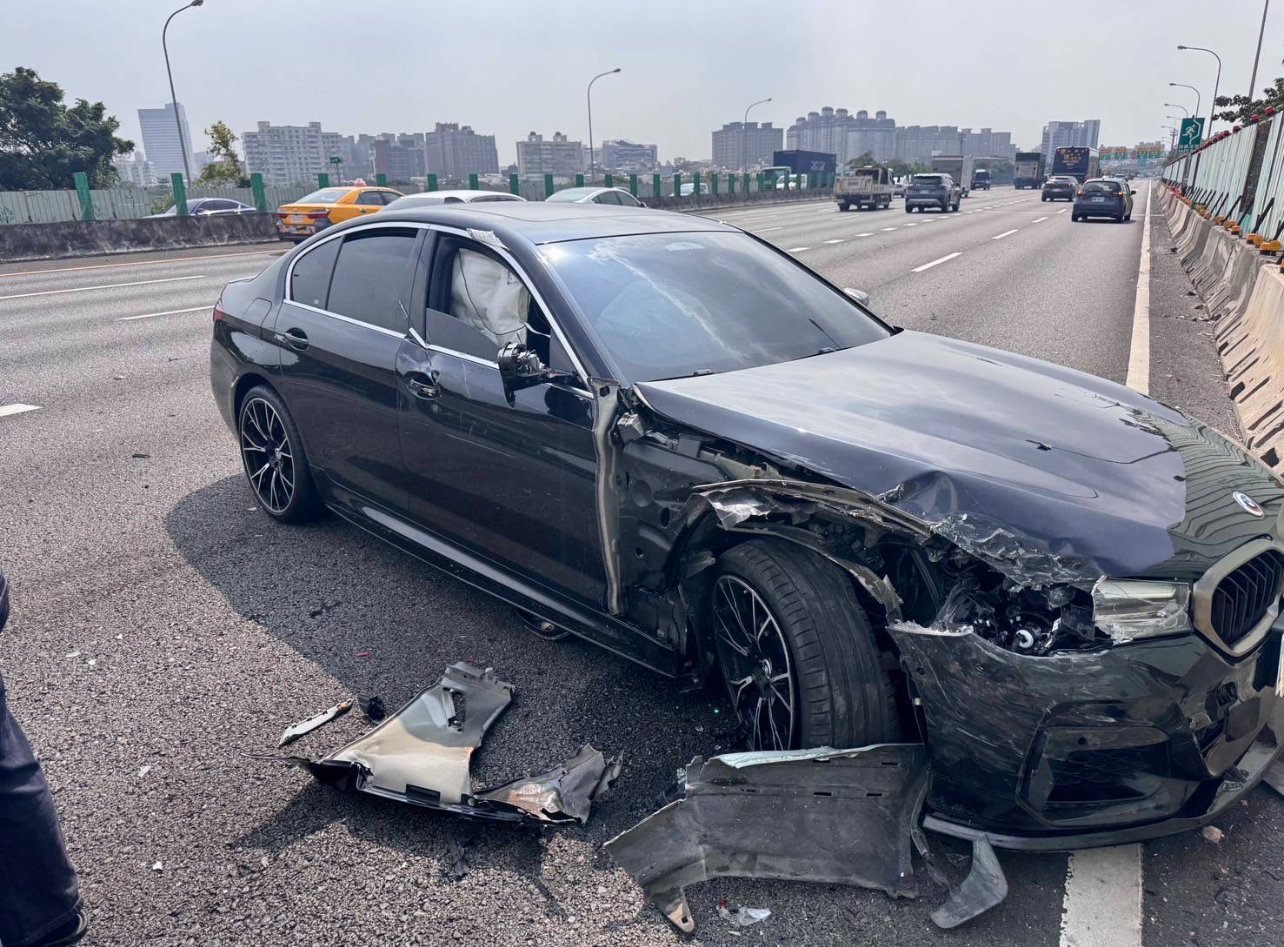 一輛深灰色BMW 530i G30豪華轎車在高速公路上發生嚴重側面撞擊事故,右側車身嚴重變形凹陷、右前輪拱受損、車門變形、車窗破損,地面散落大量車身碎片,具有BMW標誌性的雙腎型水箱護罩和天使眼LED頭燈設計。車事通提供BMW豪華轎車事故專業評估、安全氣囊系統檢測、電子系統診斷與高價收購服務,全台24小時專業處理德系豪華車嚴重事故案例。