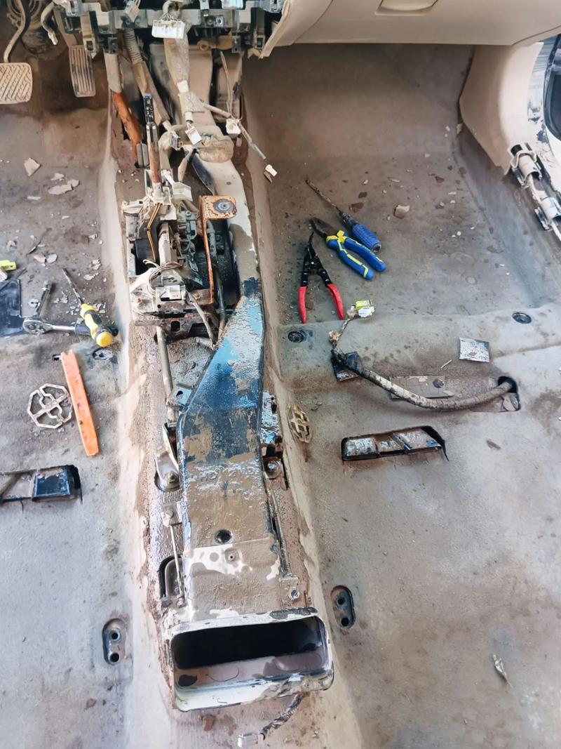 嚴重水浸的汽車內部，座椅、地毯與電子設備皆受損，顯示泥水與鏽蝕