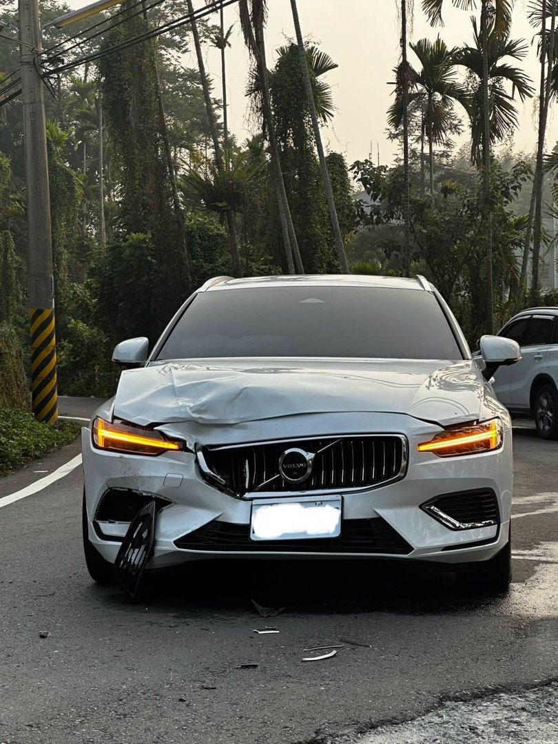 一輛白色Volvo V60豪華旅行車發生前端撞擊事故，前保險桿、引擎蓋、頭燈等部位受損變形，具有Volvo標誌性的雷神之錘LED日行燈設計。車事通提供Volvo V60旅行車事故專業評估、安全系統檢測、歐系豪華車零件評估與高價收購服務，全台24小時專業處理豪華旅行車事故案例。